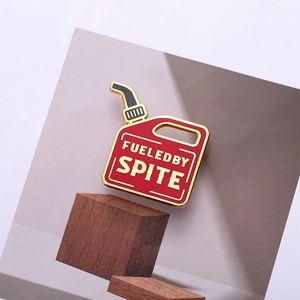 Detail of red gasoline can enamel pin with Fueled By Spite text and gold metal trim