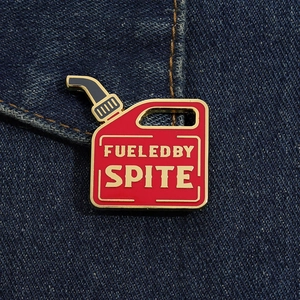 Macro shot of red gasoline can enamel pin with 'Fueled by Spite' on denim fabric