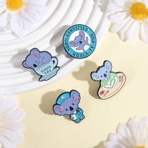 Close-up of four cute koala enamel pins with koala-tea and certified puns for bag decor