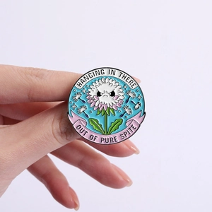 Funny flower enamel pin with Hanging In There and Out Of Pure Spite slogan on hand