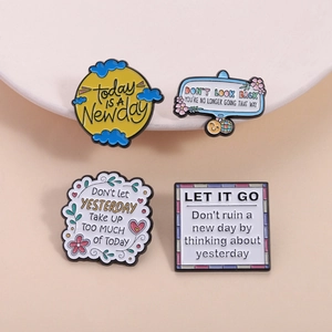 Set of four colorful enamel lapel pins with inspirational quotes and floral motifs