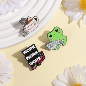 Macro detail of enamel workplace humor pins featuring a cat in a cup and a busy frog