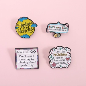 Set of four inspirational enamel pins with uplifting quotes and colorful cartoon designs