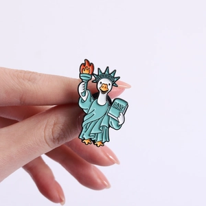 Vue détaillée du pin's émaillé oie Statue de la Liberté avec texte HONK sur fond blanc