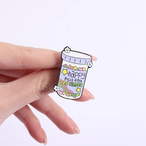 Close-up of Happy Pills enamel pin featuring a rainbow and stars on a purple bottle