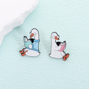 Cute enamel goose brooches featuring geeky geese reading books with round glasses
