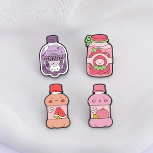 Detail of four colorful fruit drink enamel pins including grape and strawberry motifs