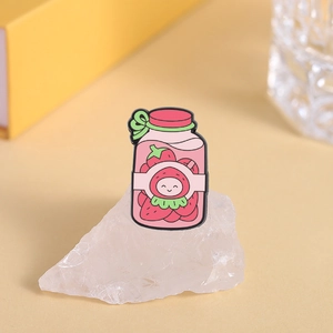 Close-up of strawberry canned beverage enamel pin on crystal stone with soft lighting