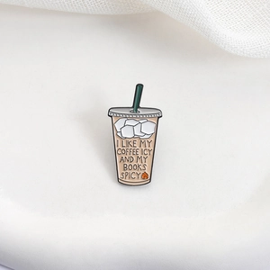 Detail of coffee cup enamel pin with I LIKE MY COFFEE ICY AND MY BOOKS SPICY text