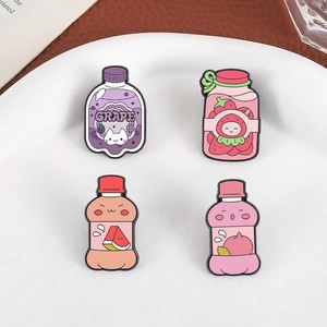 Detailed view of four colorful fruit-themed enamel pins shaped like cartoon drink bottles
