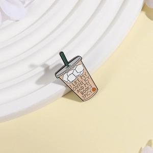 Detail of coffee cup enamel pin with I LIKE MY COFFEE ICY AND MY BOOKS SPICY text