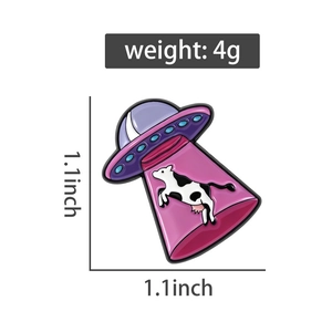 Détail macro du pin's OVNI avec vache montrant la taille 1,1x1,1 pouce et le poids de 4g