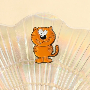 Nahaufnahme einer orangefarbenen Katzen-Emaille-Pin in einer Perlglanz-Schale mit Katzengesicht