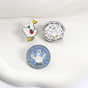 Three cute enamel duck badges with humorous quotes on a white textured background