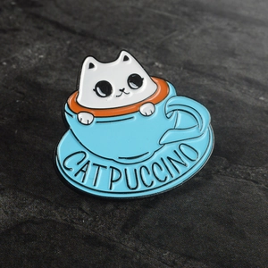 Cute enamel catpuccino pin featuring a blue coffee cup cat design on stone background