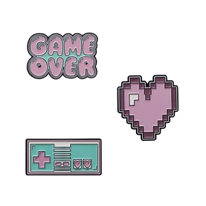 Retro gaming enamel pin set featuring purple pixel heart and game over design