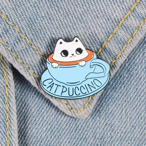Cute white cat in a blue Catpuccino coffee cup enamel pin on denim jacket