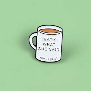 Detail of coffee mug enamel pin featuring the phrase That's What She Said on green background