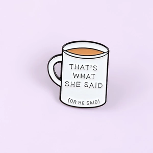 Detail view of coffee cup enamel pin featuring 'THAT'S WHAT SHE SAID' quote engraving