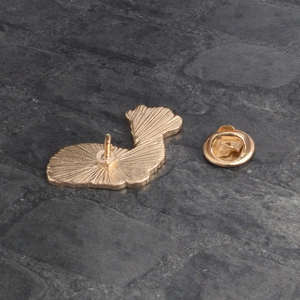Vue arrière d'une broche alpaga dorée en émail avec fermoir papillon sur pierre