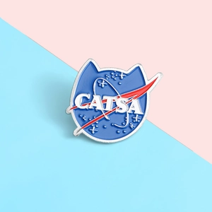 Detail of CATSA blue cat enamel pin with NASA logo style on colorful background