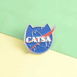 Macro shot of CATSA enamel pin with cat silhouette and NASA inspired space design