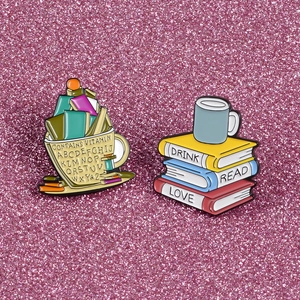 Détail de pins en émail mignons avec tasse à café et livres sur fond rose pailleté