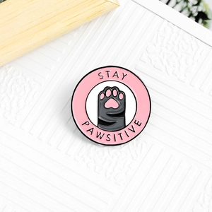 Badge en émail patte de chat avec slogan Stay Pawsitive et détail de coeur rose