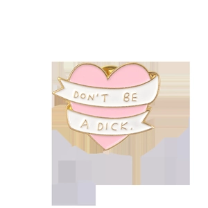 Pink heart enamel pin with gold edges and Don't Be A Dick slogan ribbon decoration