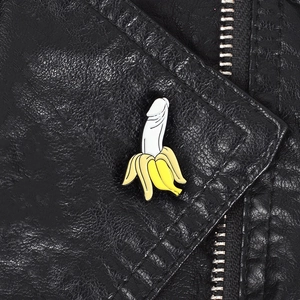 Detailed view of banana-shaped enamel pin on a black leather jacket lapel
