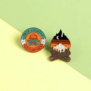 Detailed outdoor camping enamel badges featuring campfire and Pack Lighter slogan