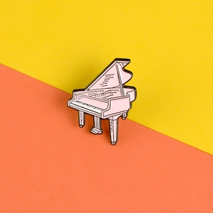 Détail macro d'une broche en émail piano à queue rose avec finition en alliage poli