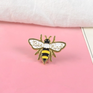 Broche abeille émaillée avec lettrage Bee Kind sur fond rose pour accessoires
