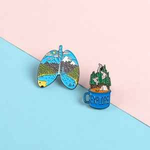 Detail of enamel lapel pins featuring scenic mountain lung and explore camping mug