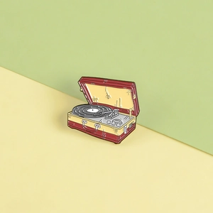 Macro view of a vintage record player enamel pin with detailed turntable and arm features