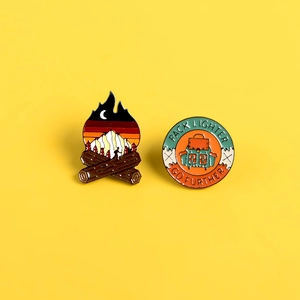 Creative outdoor theme campfire and backpack enamel pins on bright yellow background
