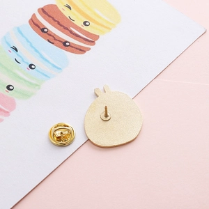 Detail of golden enamel pin back with butterfly clutch on a decorative card