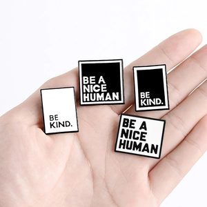 Minimalist enamel pin set featuring BE KIND and BE A NICE HUMAN quotes on hand