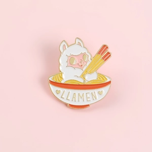 Detail of creative llama ramen enamel pin with golden LLAMEN text on a pink background