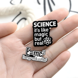 Set of creative science enamel pins featuring atom symbols and E=mc2 milk coffee formulas