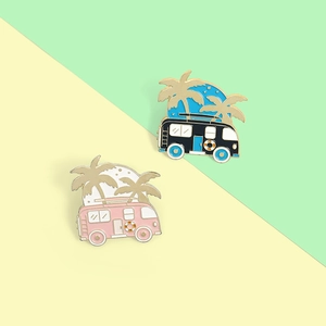 Detailed close-up of colorful RV and palm tree enamel pins with golden outlines