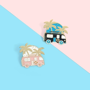 Close-up of colorful enamel camper van brooches with palm trees on split background