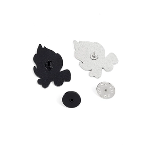 Detail of flame enamel pins back with black rubber clutches and silver metal butterfly clasps