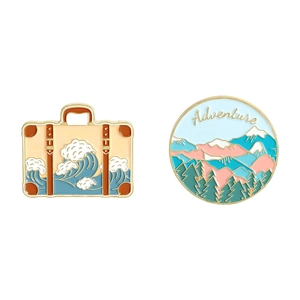 Set of travel themed enamel pins featuring ocean waves suitcase and adventure mountains