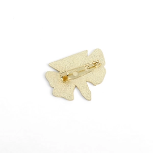 Detail view of the secure safety pin back and golden alloy texture of the insect brooch