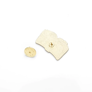 Detail view of the golden metal enamel pin back with fine textured finish and clutch