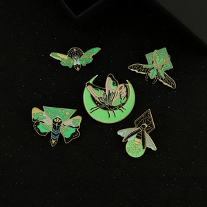 Five-piece set of glow-in-the-dark insect enamel pins featuring moths and butterflies