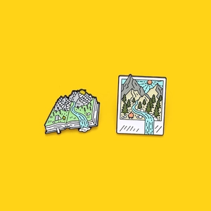 Cartoon enamel pins set featuring mountain landscape book and Polaroid frame designs