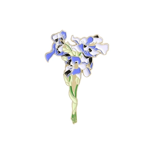 Détail macro de la broche iris en émail avec pétales bleu foncé et bords dorés