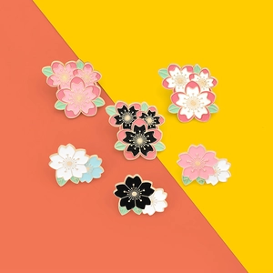 Detailed close-up of six Japanese cherry blossom enamel pins with colorful lacquer finish